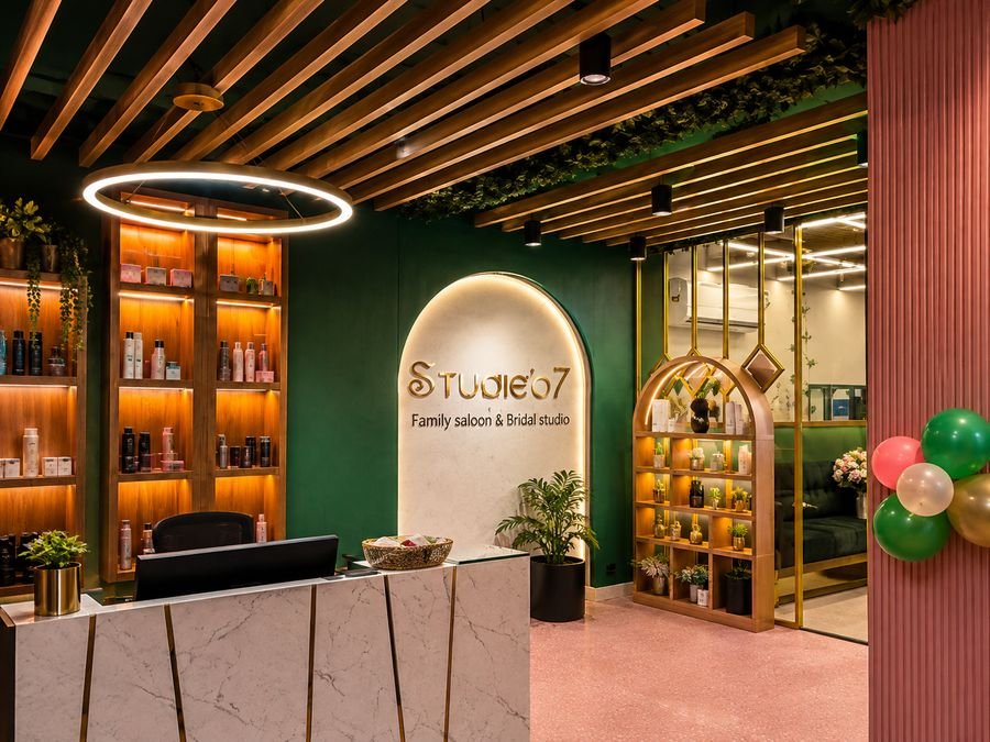Studie'o7 reception desk with backlit product shelving and gold ring light